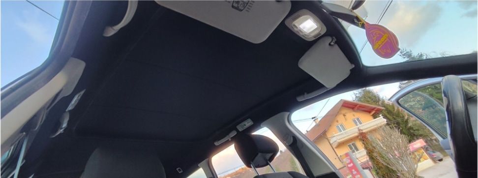 Unutrašnjost automobila sa presvučenim crnim nebom, štitnicima za sunce i plafonjerom